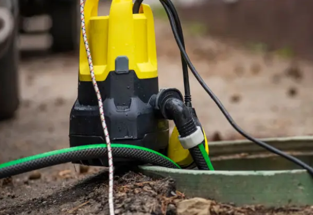 Pump and hose set up beside a septic access lid during a maintenance visit